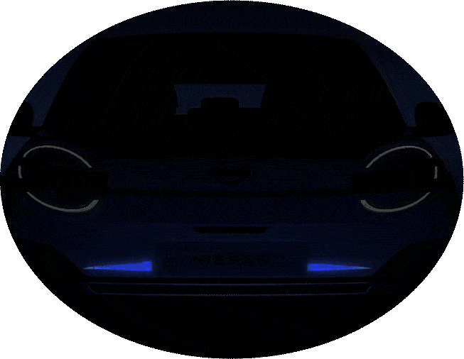 Front view of a car with illuminated circular headlights in low light.