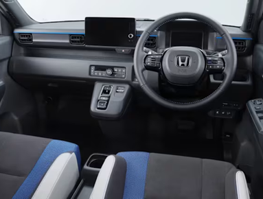 Interior of a car showing the steering wheel, dashboard, and seating arrangement.