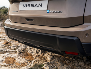 Rear view of a Nissan e-Power car parked on rocky ground.