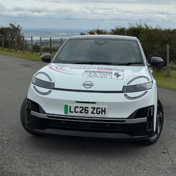 White Nissan car with licence plate LC26 ZGH on a road.