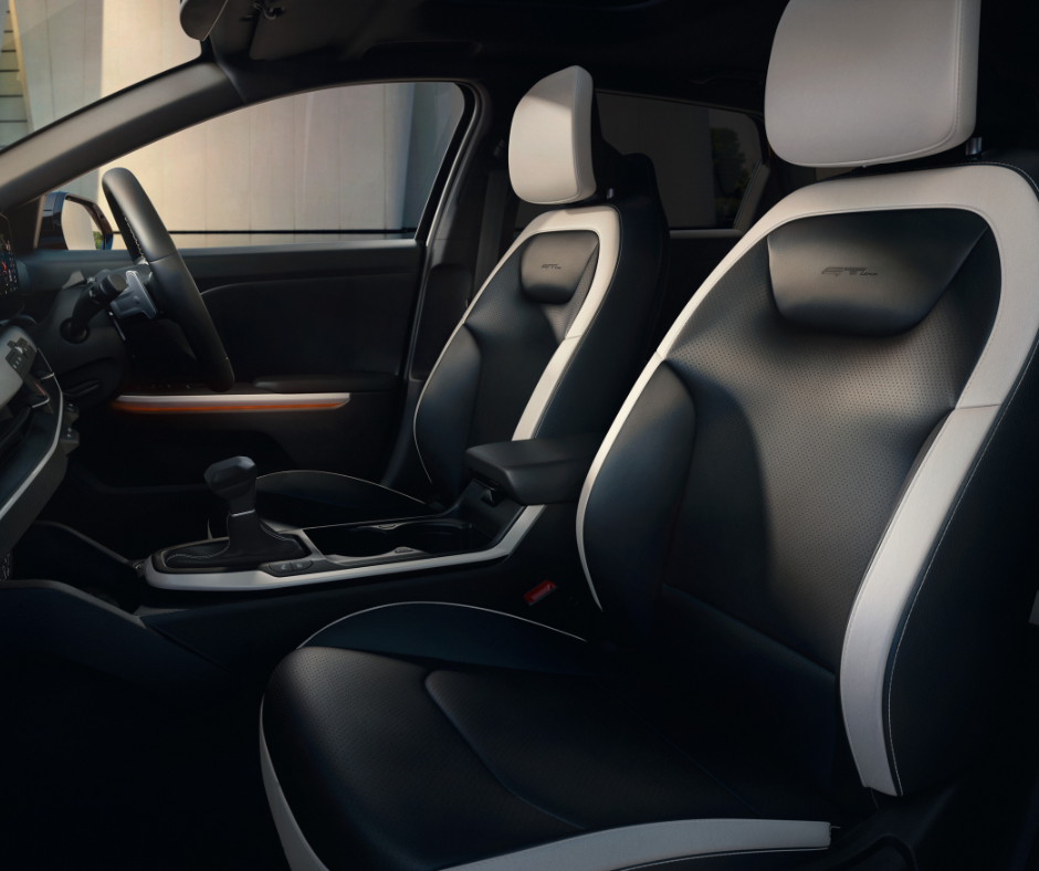 Interior of a car showing front seats and steering wheel in black and white leather upholstery.