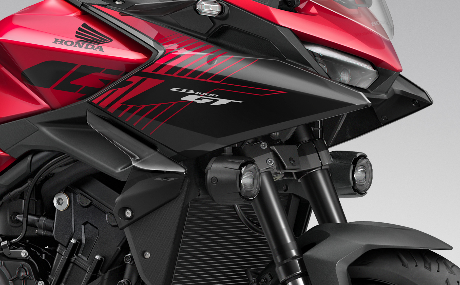 Close-up of a motorcycle's front, showing the Honda CB1000 GT logo and red accents.