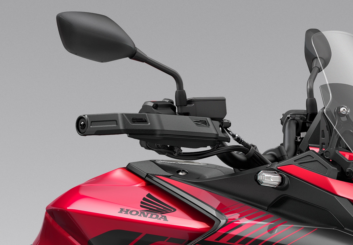 Close-up of a red Honda motorcycle handlebar and side mirror.