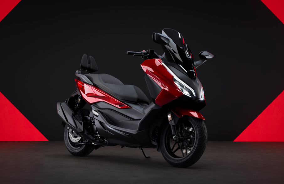 Red and black modern scooter with a windshield.