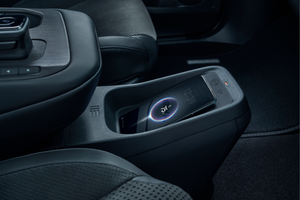 Smartphone charging in the centre console of a car interior.
