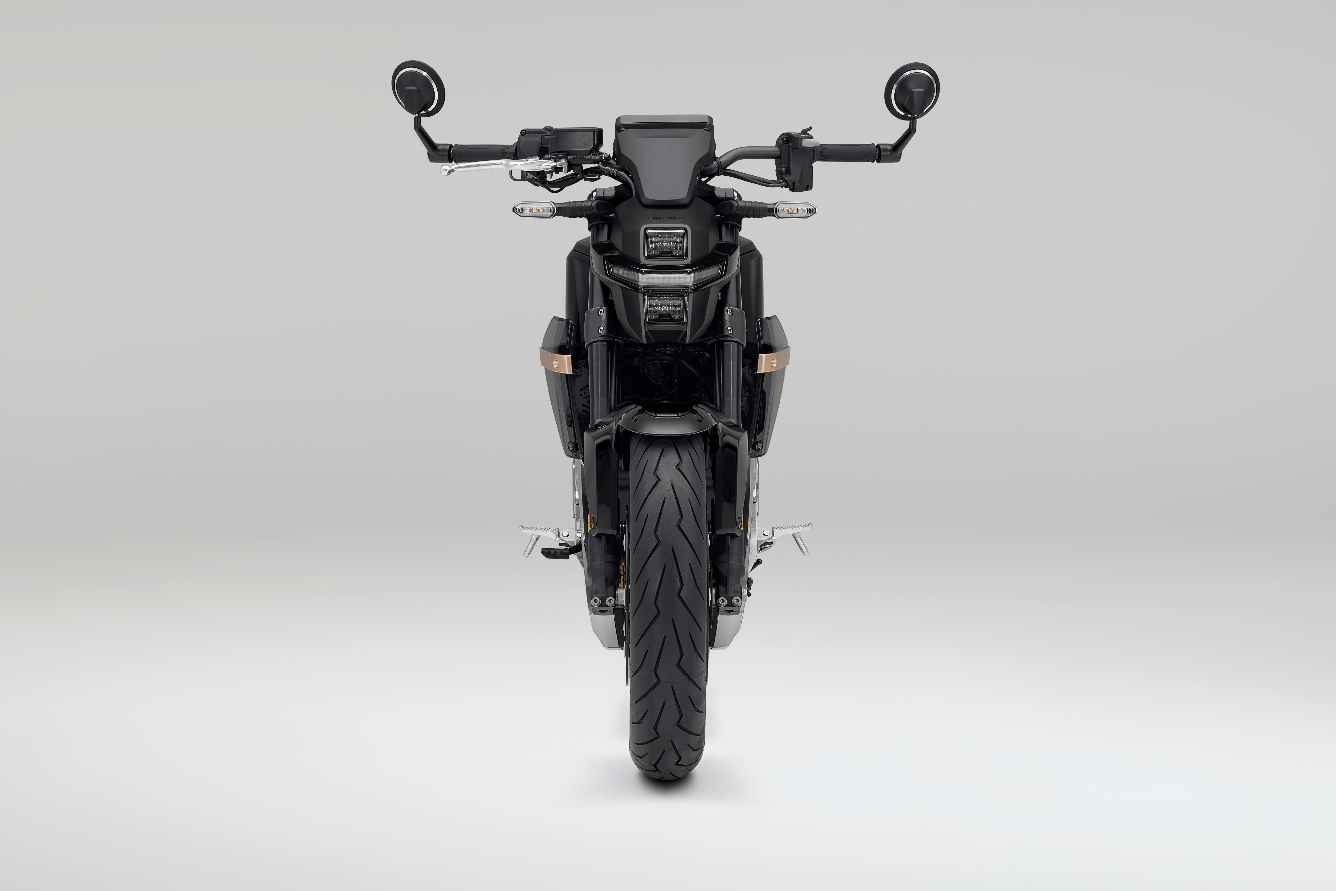 Front view of a black motorcycle with round mirrors and handlebars.