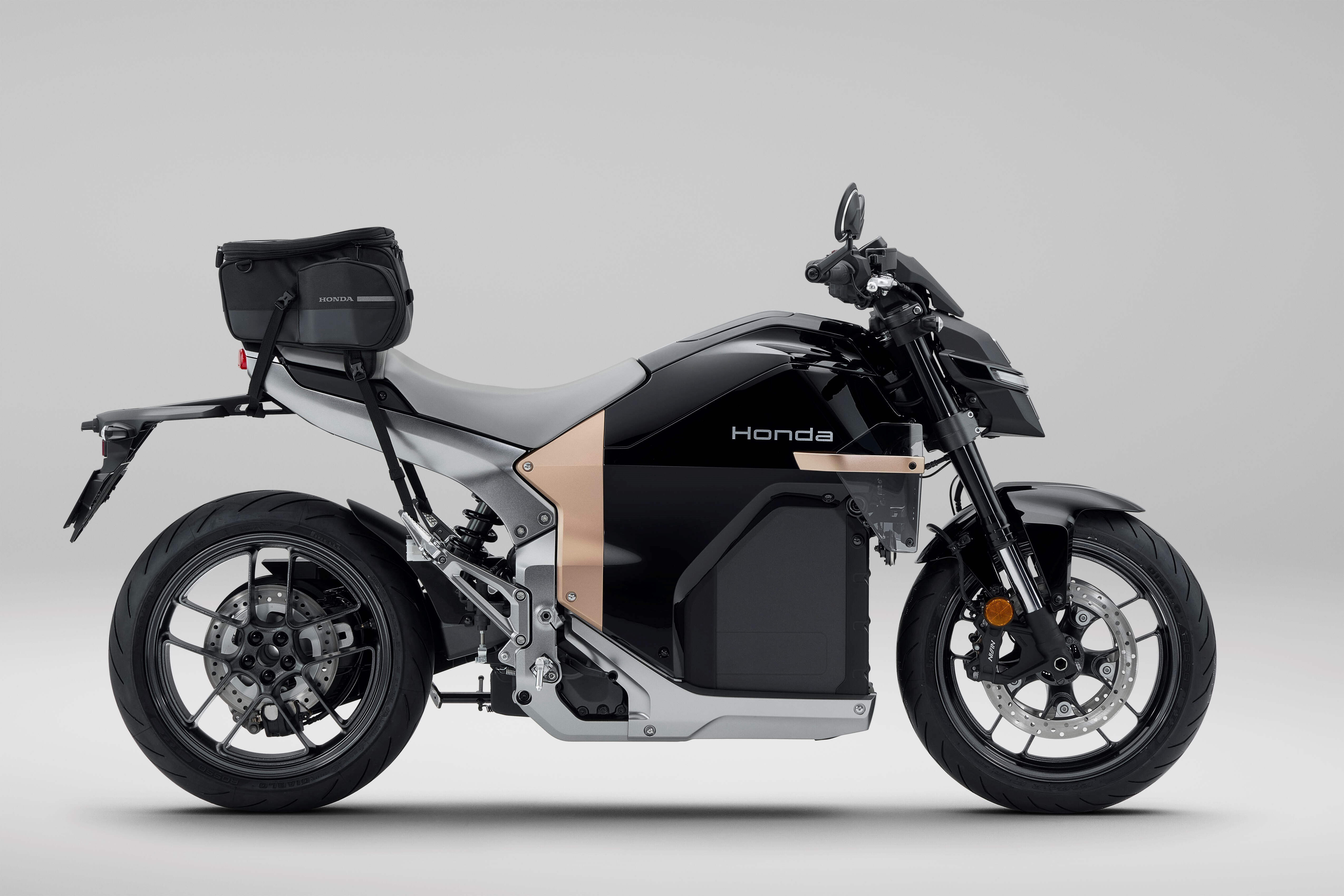 Black Honda motorcycle with copper accents and a rear storage bag.