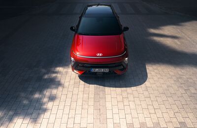 Red Hyundai crossover vehicle viewed from above on a paved surface.