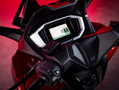 Close-up of a motorcycle's digital dashboard and handlebars.