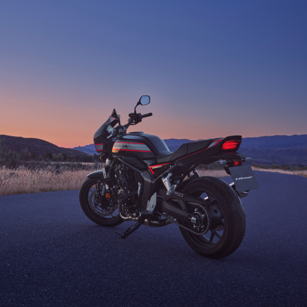 Motorbike parked on a road at sunset.