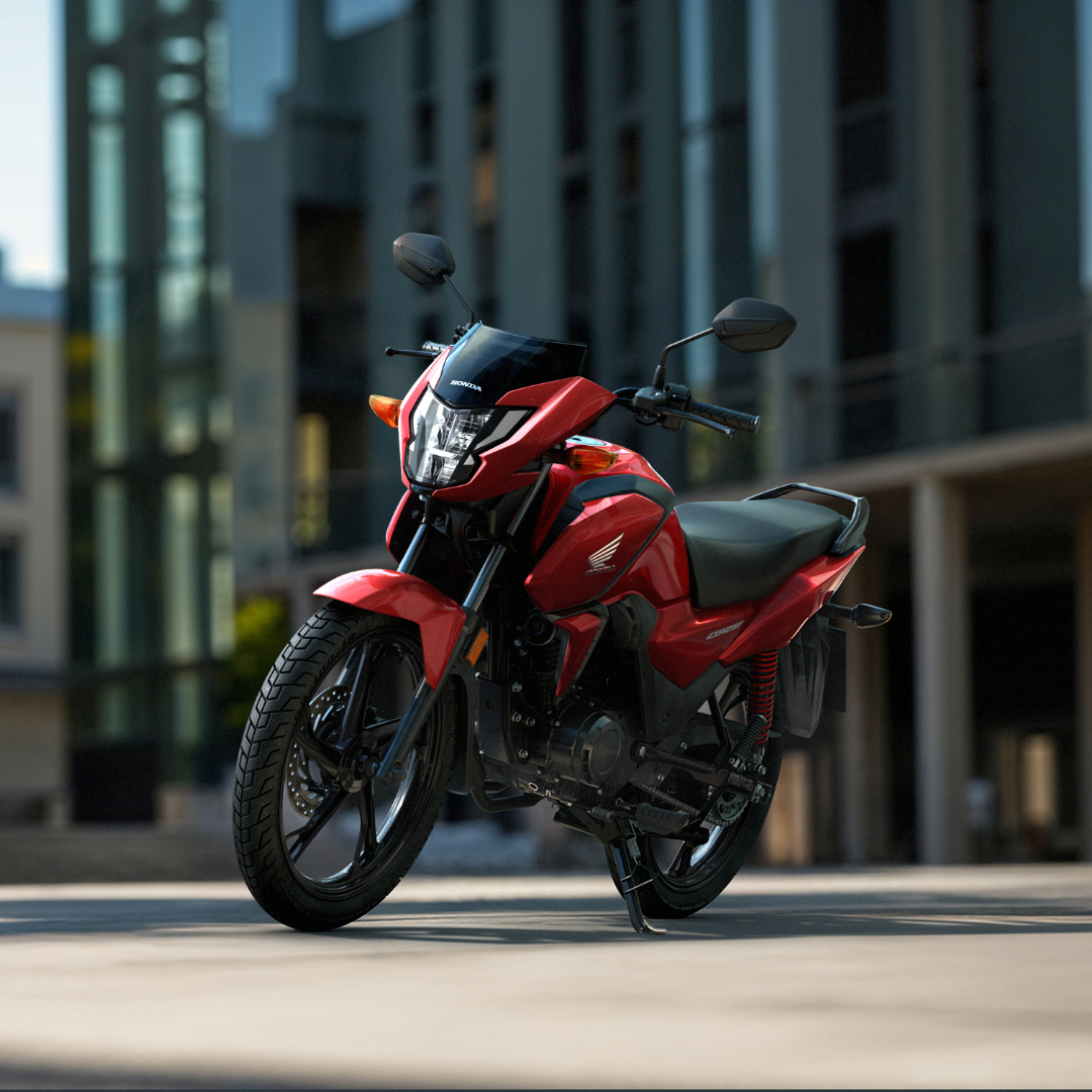 Red Honda motorcycle parked on an urban street.