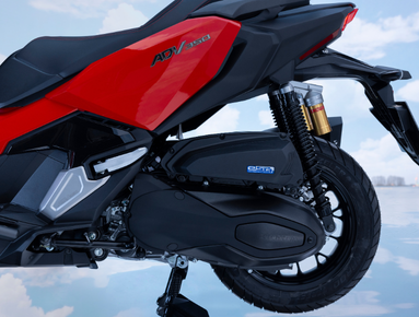Close-up of a red motorcycle focusing on the rear wheel and suspension system.