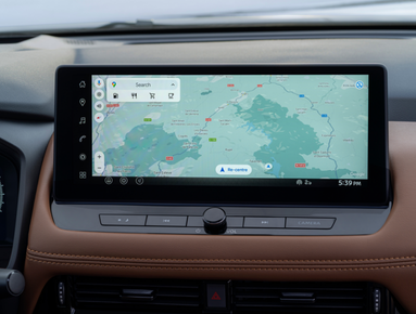 Car dashboard touchscreen displaying a map with route guidance and search options.