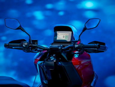 Close-up of a motorcycle dashboard with mirrors and digital display.