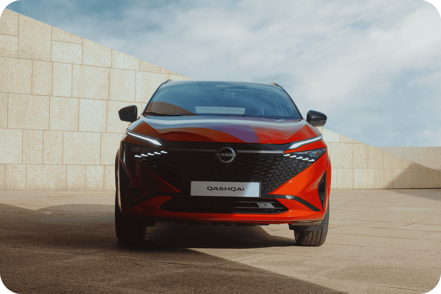 Red Nissan Qashqai car shown from the front with visible headlight design.