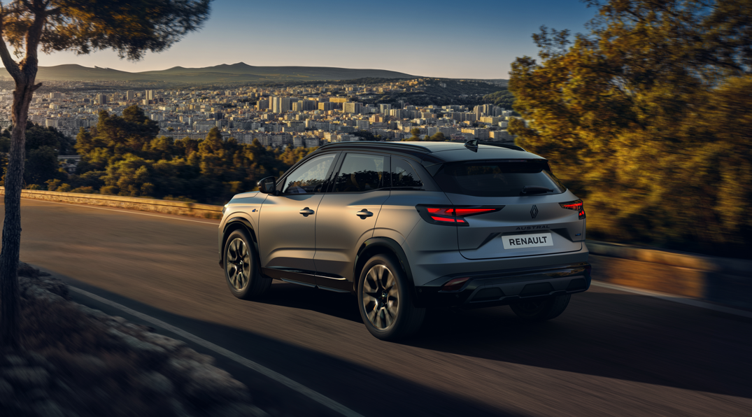 Silver Renault SUV driving on a scenic road.