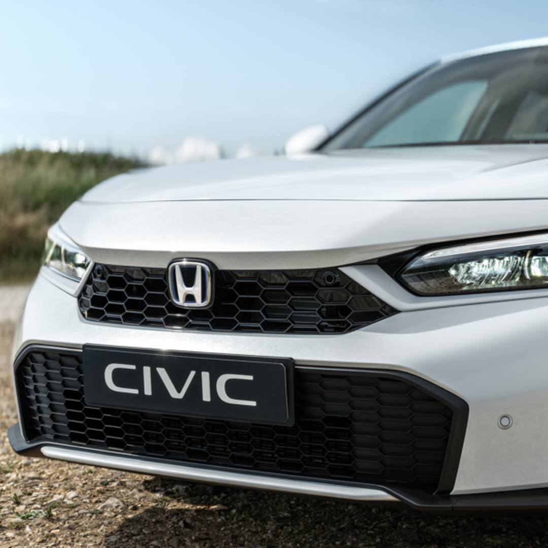 Front view of a white Honda Civic car's grille and headlights.