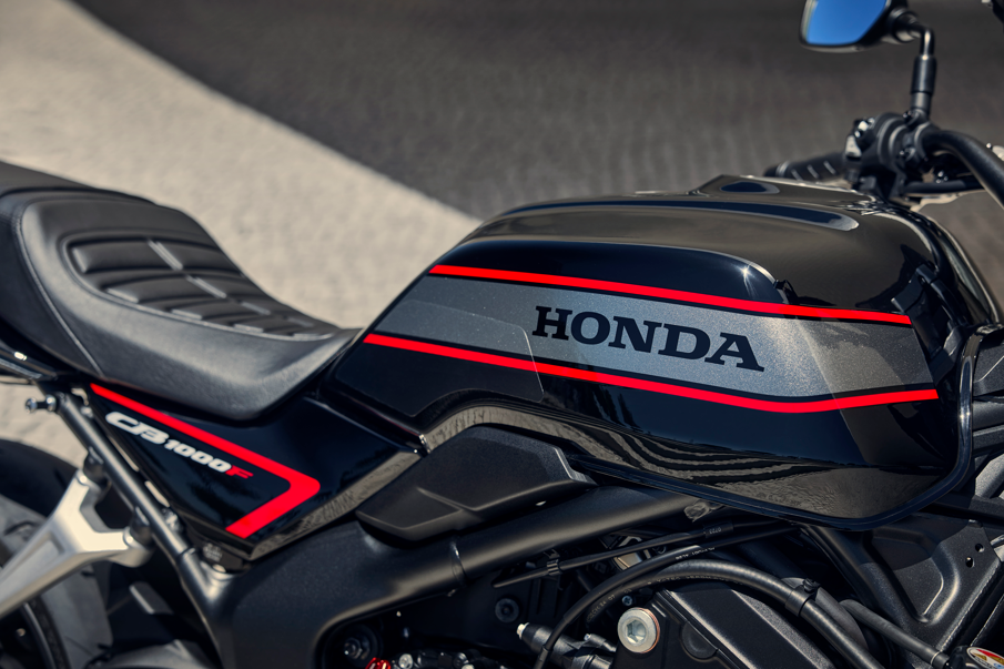 Close-up of a Honda CB1000R motorcycle tank with red stripes.