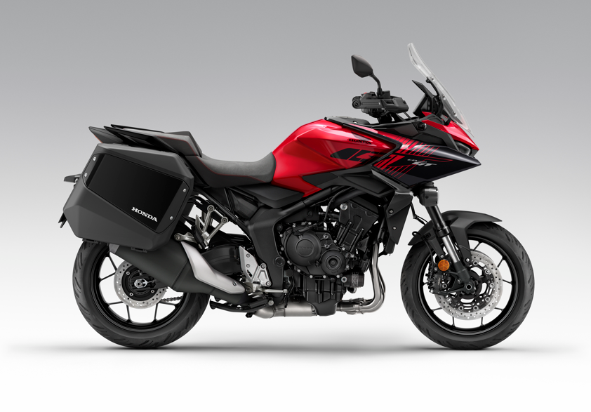Red touring motorcycle with side panniers, viewed from the right side.