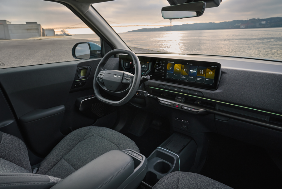 Interior of a car showing steering wheel and digital dashboard display.