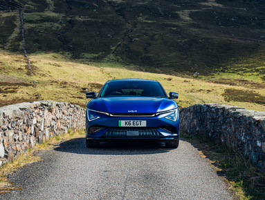 Blue car on a rural stone bridge, front view, with UK registration plate K6 EGT.