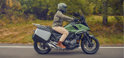 Green Honda NC750X being ridden on a forested road
