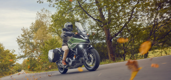 Green Honda NC750X being ridden on a windy forest road