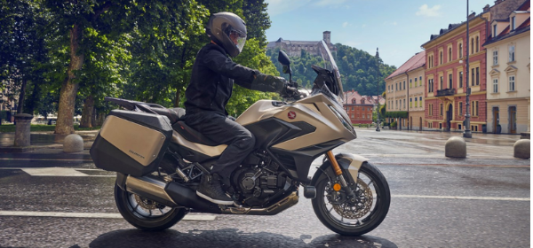 Person riding a Honda touring motorcycle on a city street.