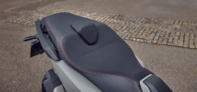Close-up of a motorcycle seat with red stitching and branding.