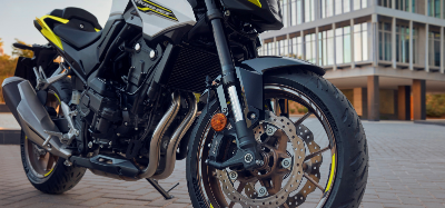 Close-up of a black and yellow motorcycle parked on a paved surface.