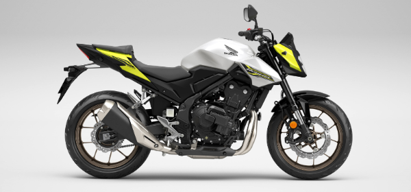 A Honda motorcycle in white and black with yellow accents, viewed from the right side.