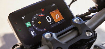 Close-up of a motorcycle digital display showing speed and music controls.