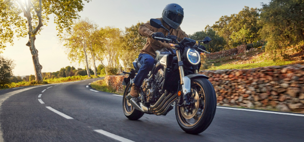 Person riding Honda CBR650R on winding road