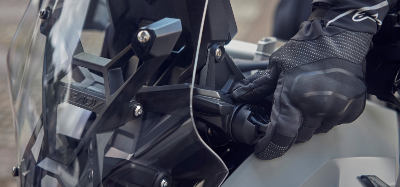 Gloved hand adjusting motorcycle windscreen mount.
