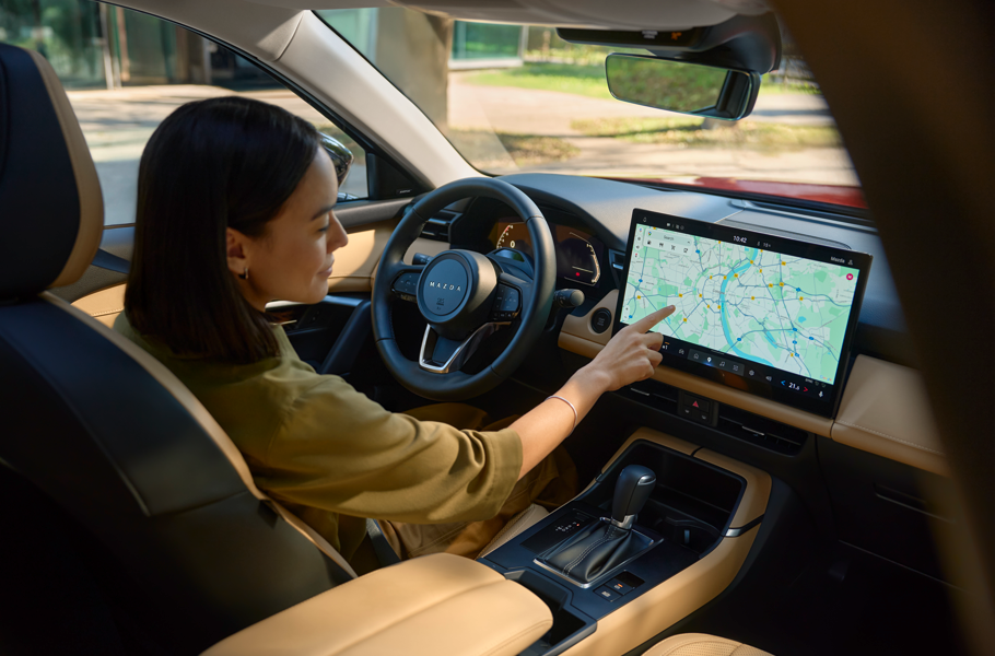 Woman using a touchscreen in a car's interior.
