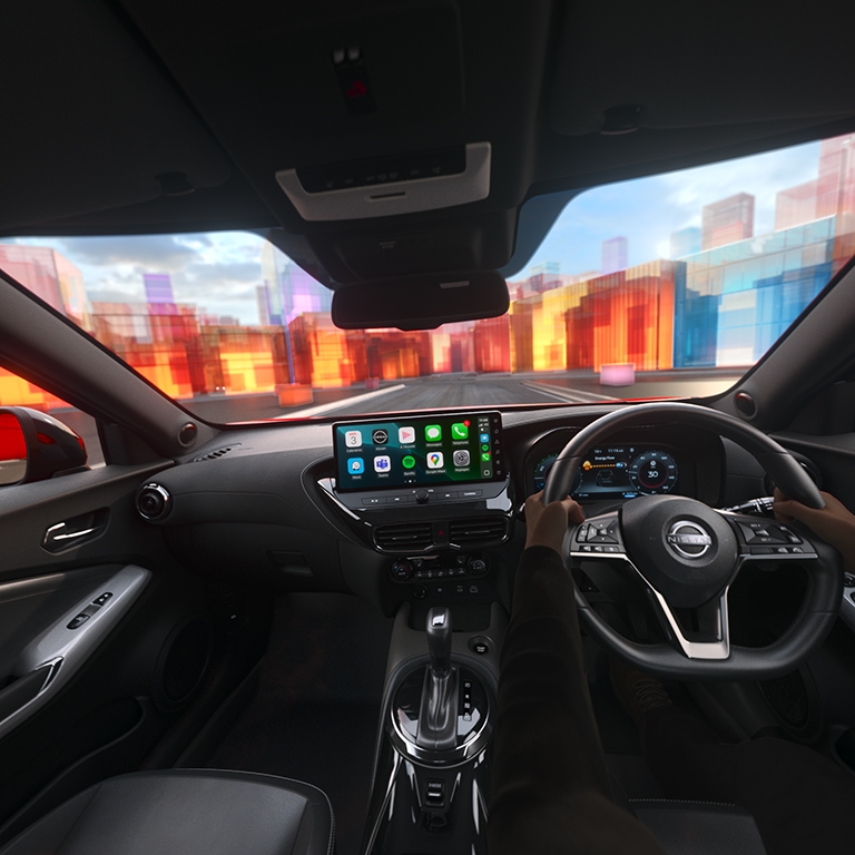 Inside view of a car with dashboard displays and hands on the steering wheel.