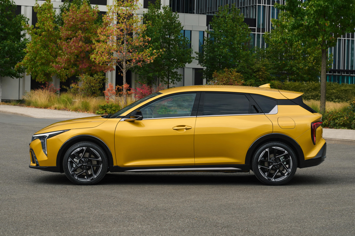 A gold electric vehicle parked next to a cactus and potted plants.