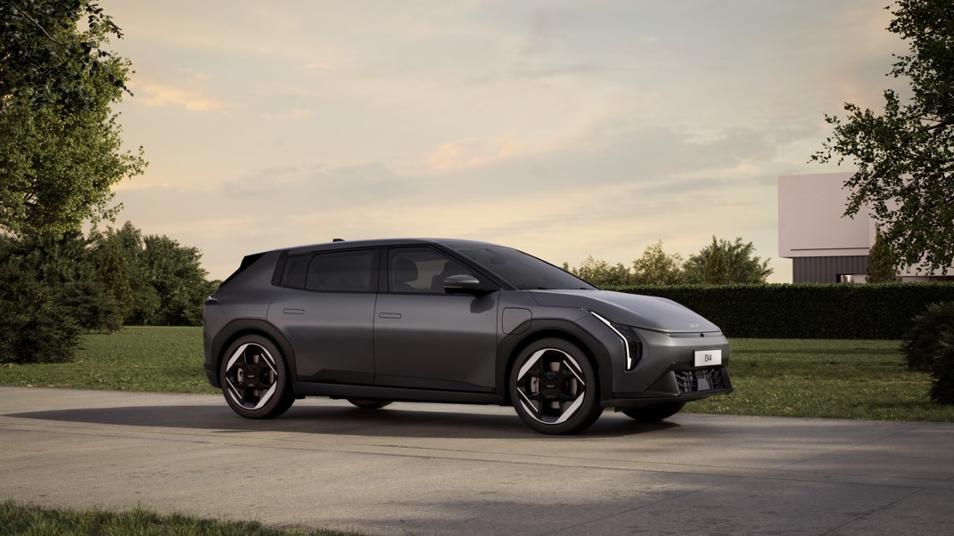 Sleek dark grey electric car parked on a driveway, viewed from the side.