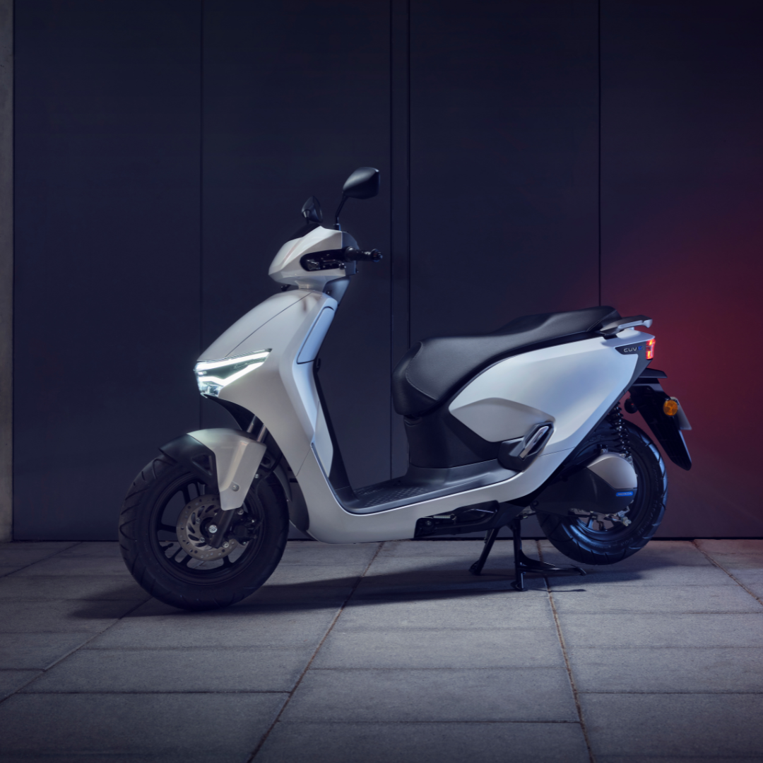 A white modern scooter parked on a paved surface.