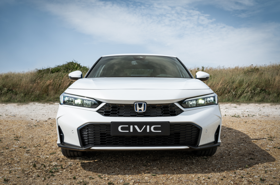 Front view of a white Honda Civic parked on gravel.