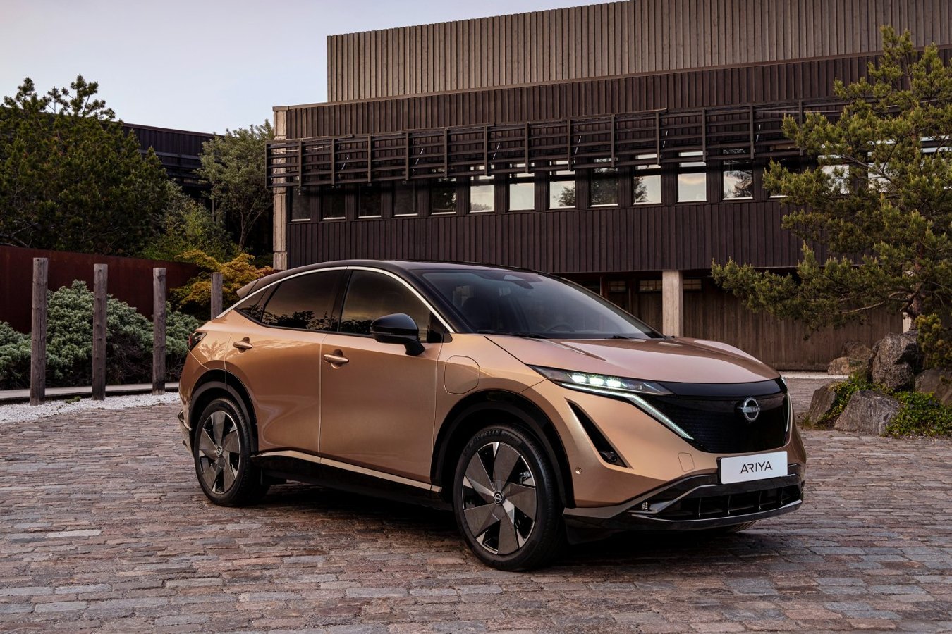 A beige Nissan Ariya electric SUV parked outdoors.