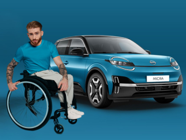 Man in a wheelchair next to a blue car with Micra on the number plate.