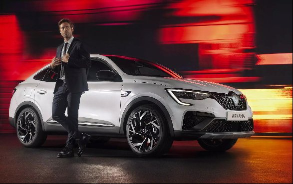Man in a suit standing beside a white car.