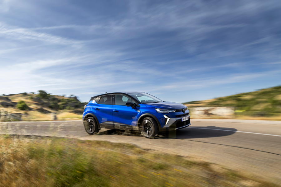 Blue SUV driving on a rural road with motion blur.