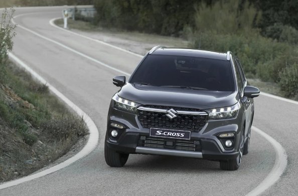 A black Suzuki S-Cross driving on a road.
