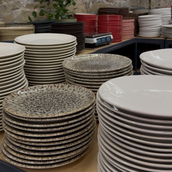 Stacks of ceramic plates in various colours and patterns on display.